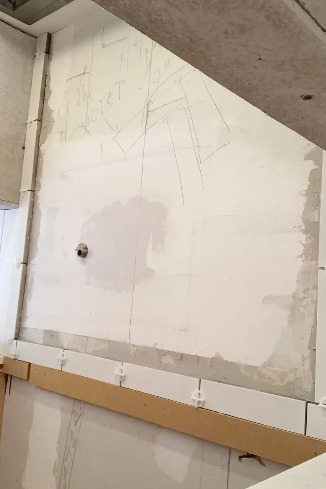 Using a ledger board to start a tile backsplash.